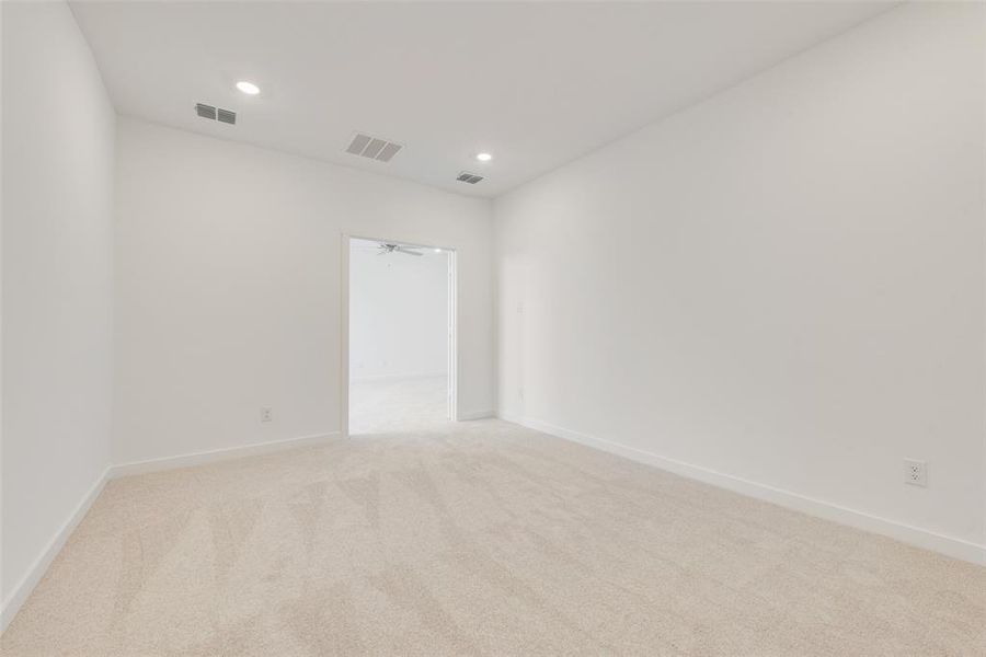 Empty room with light carpet and ceiling fan