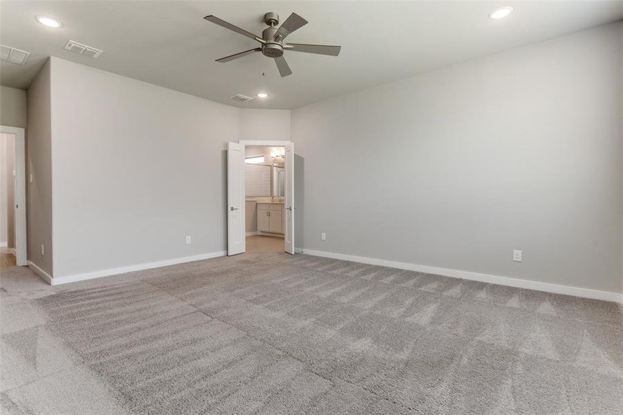 Spare room with ceiling fan and carpet flooring