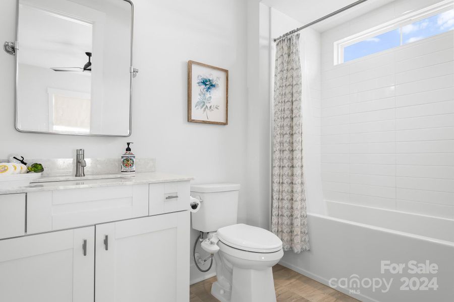 Ensuite bath for bedroom 2.  Lots of natural light is brought into the bathroom from the transom window over the tub/shower area.