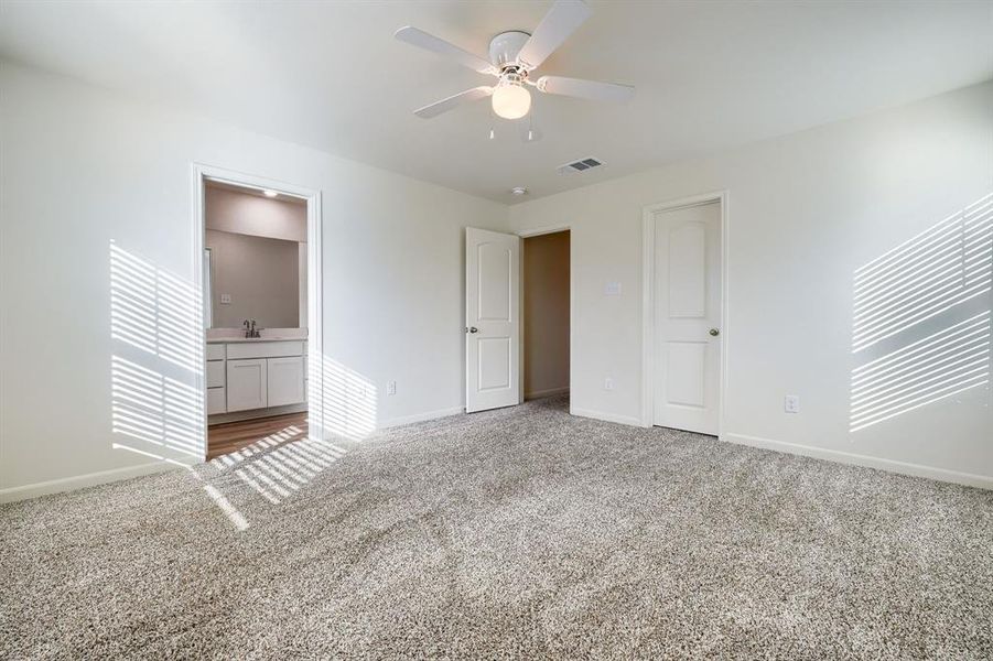 Unfurnished bedroom featuring carpet flooring, sink, connected bathroom, and ceiling fan