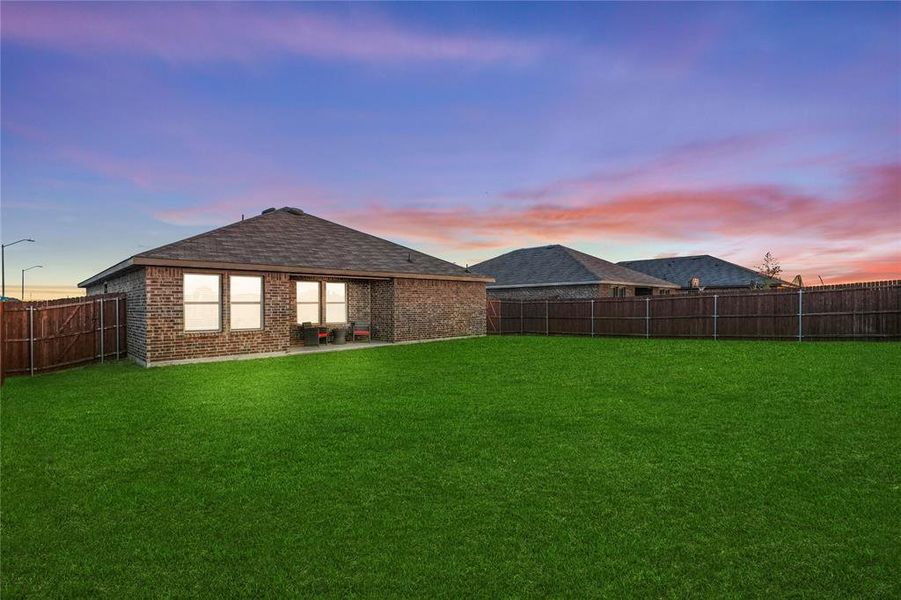 Yard at dusk featuring a covered patio area