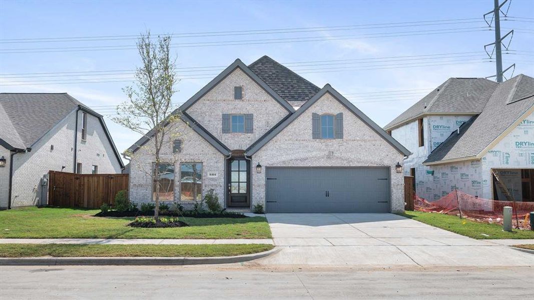 View of front facade featuring a garage and a front yard