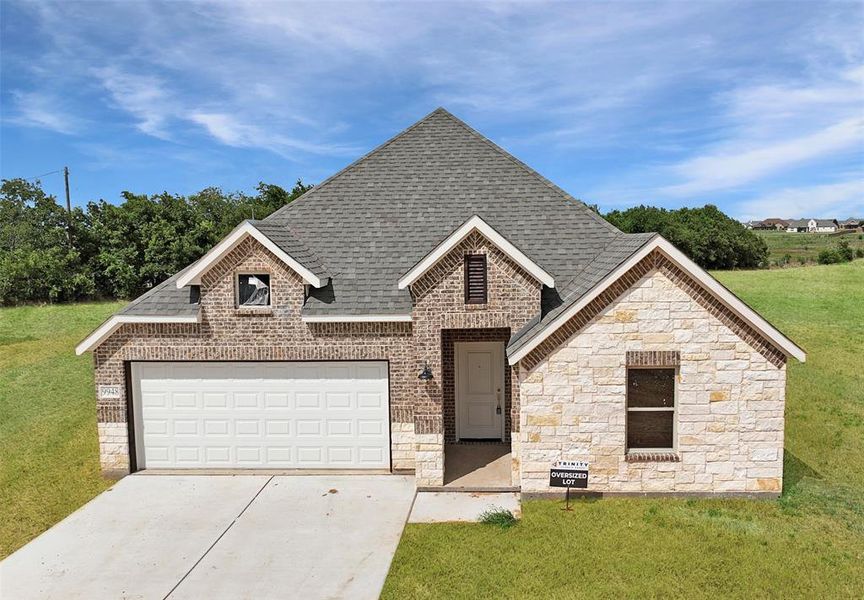 View of front facade featuring a garage and a front lawn