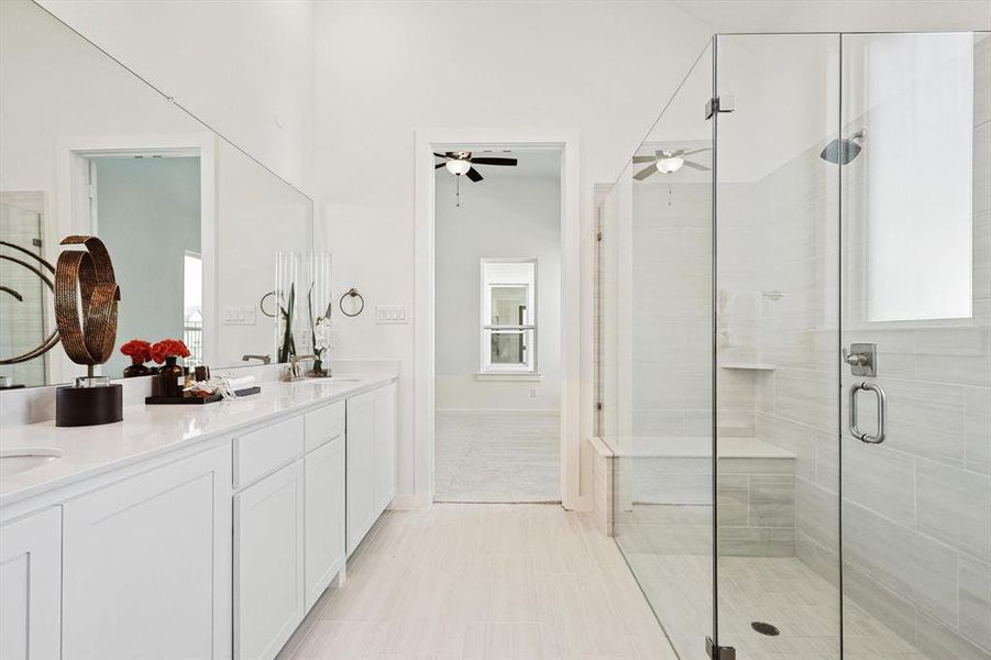 Bathroom featuring tile floors, a shower with door, ceiling fan, and double vanity