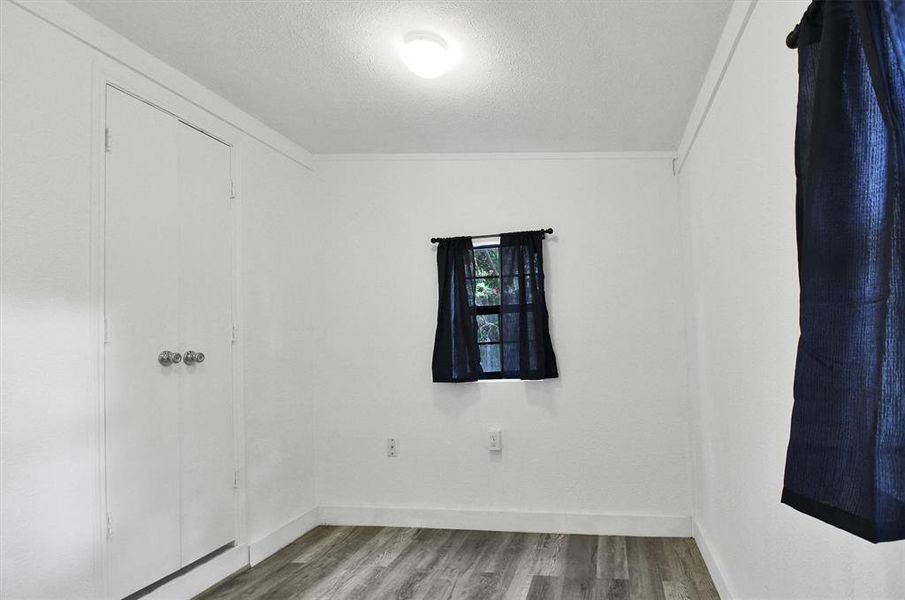 Unfurnished room with a textured ceiling and light wood-type flooring