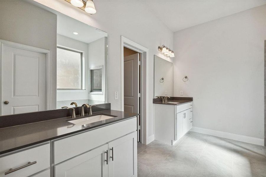 Bathroom featuring tile patterned flooring and vanity