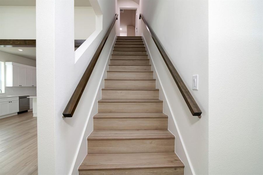 Staircase with light hardwood / wood-style flooring