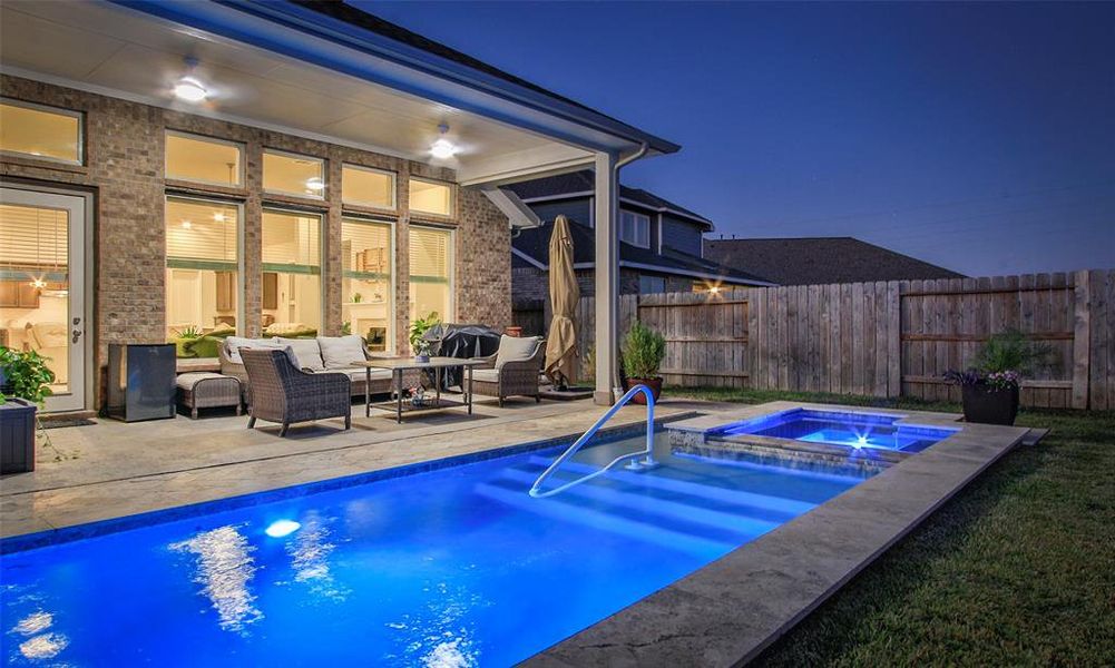 This home features a modern backyard with an inviting pool and integrated spa, complemented by a spacious covered patio area perfect for entertaining or relaxing.