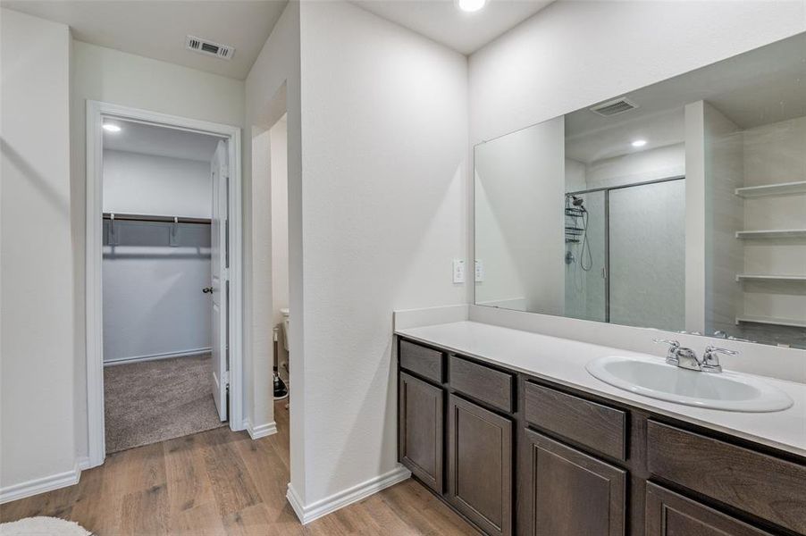 Bathroom with vanity, wood-type flooring, and an enclosed shower