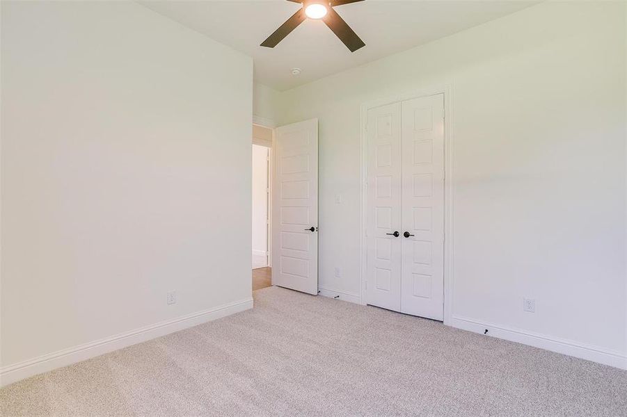 Unfurnished bedroom with light colored carpet, a closet, and ceiling fan