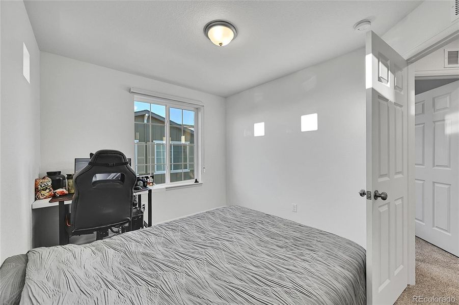 The third bedroom is found on the upper level and offers plush carpet flooring, plenty of space and a large window allowing light to shine in.