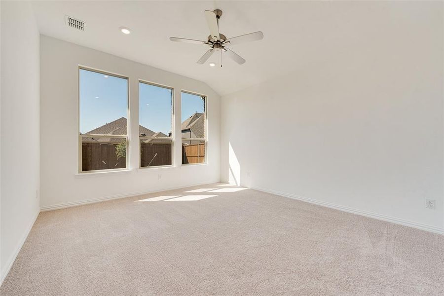 Carpeted spare room with lofted ceiling and ceiling fan