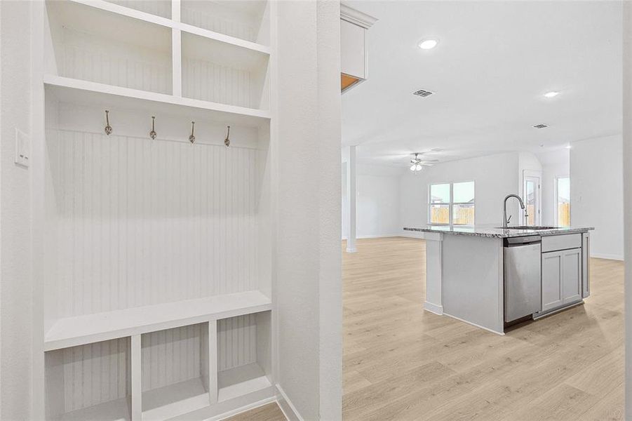 Kitchen featuring backsplash, stainless steel appliances, light hardwood / wood-style floors, sink, and a kitchen island with sink