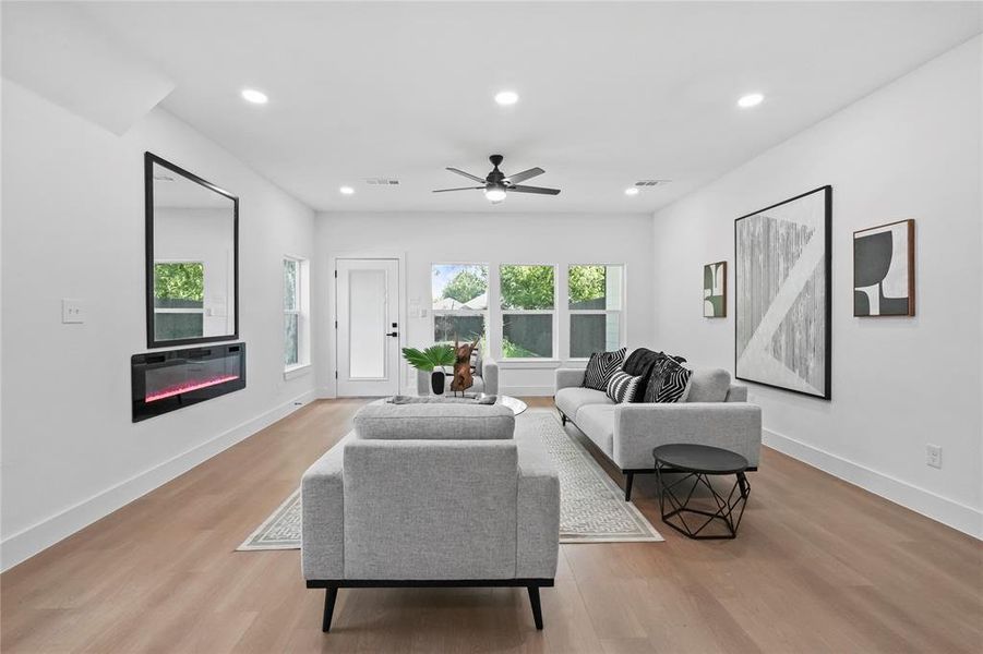 Living room featuring ceiling fan and light hardwood / wood-style floors