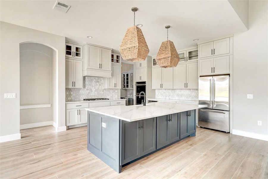 Stunning quartz counters highlighted with a marble backsplash.