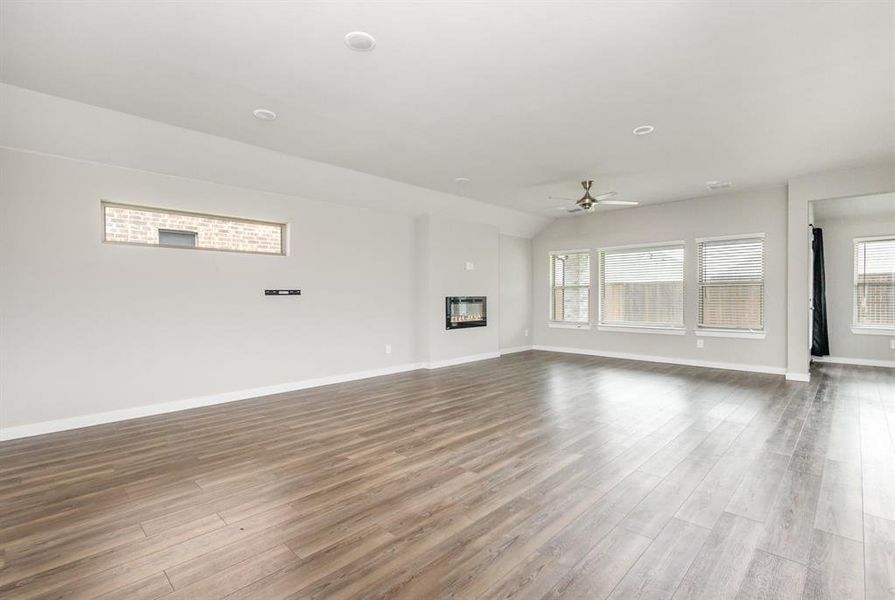 Unfurnished living room with light wood-type flooring and ceiling fan