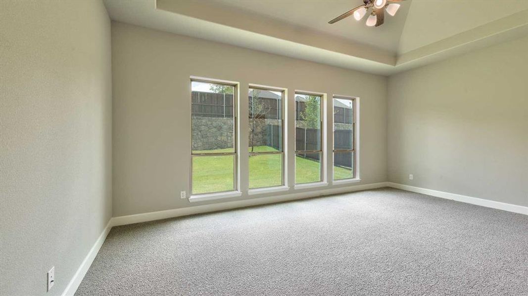 Carpeted spare room featuring ceiling fan