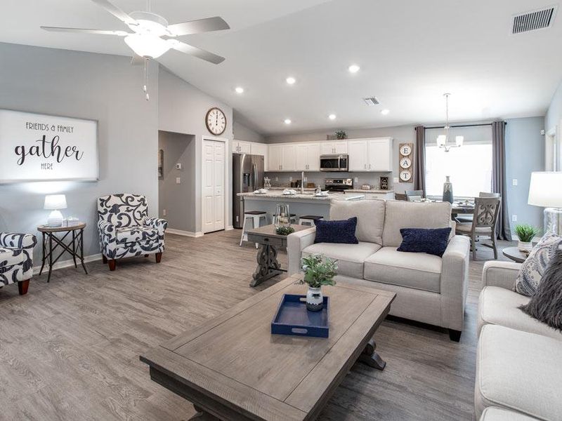 Welcoming open living area with wood vinyl plank flooring - Photo showcases a home with similar finishes. Colors and design options in actual home for sale may differ. Furnishing and décor items not included.