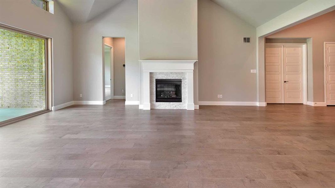 Unfurnished living room with high vaulted ceiling