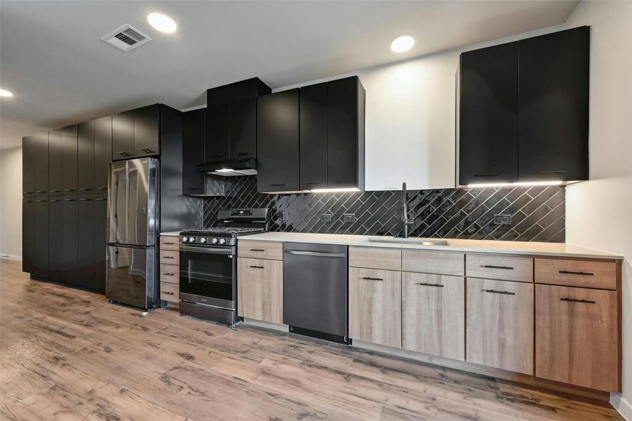 The kitchen offers ample storage. The microwave is located in the cabinet to the left of the fridge.