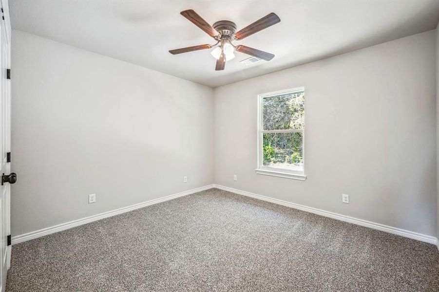 Carpeted spare room with ceiling fan