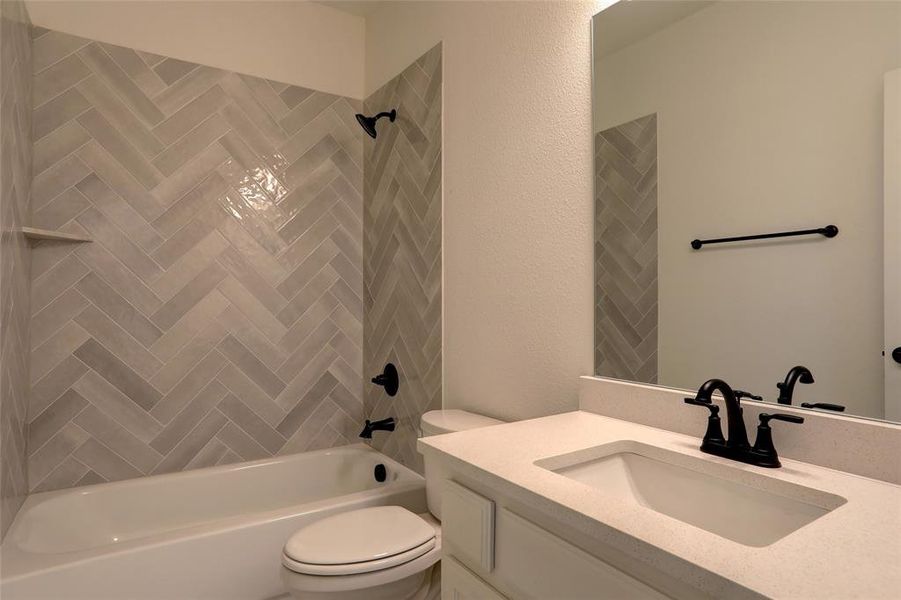 Full bathroom with vanity, toilet, and tiled shower / bath combo