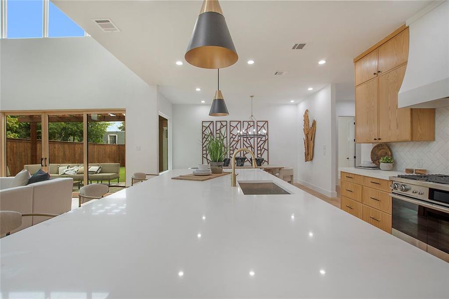 Kitchen with high end stainless steel range oven, a wealth of natural light, decorative light fixtures, and custom exhaust hood