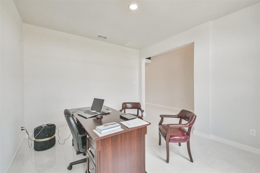 This is a bright, minimalist home office space featuring large windows that let in ample natural light.