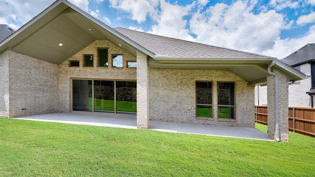 Back of house with a patio and a lawn