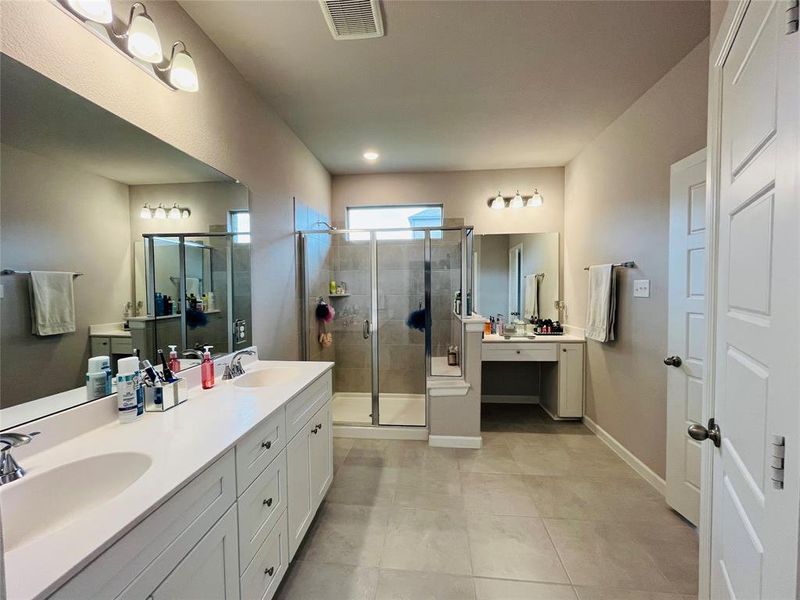 Bathroom with tile patterned floors, an enclosed shower, and vanity