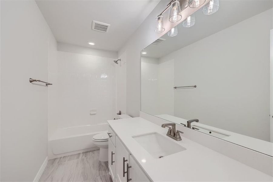 Full bathroom with shower / washtub combination, tile patterned flooring, toilet, and vanity