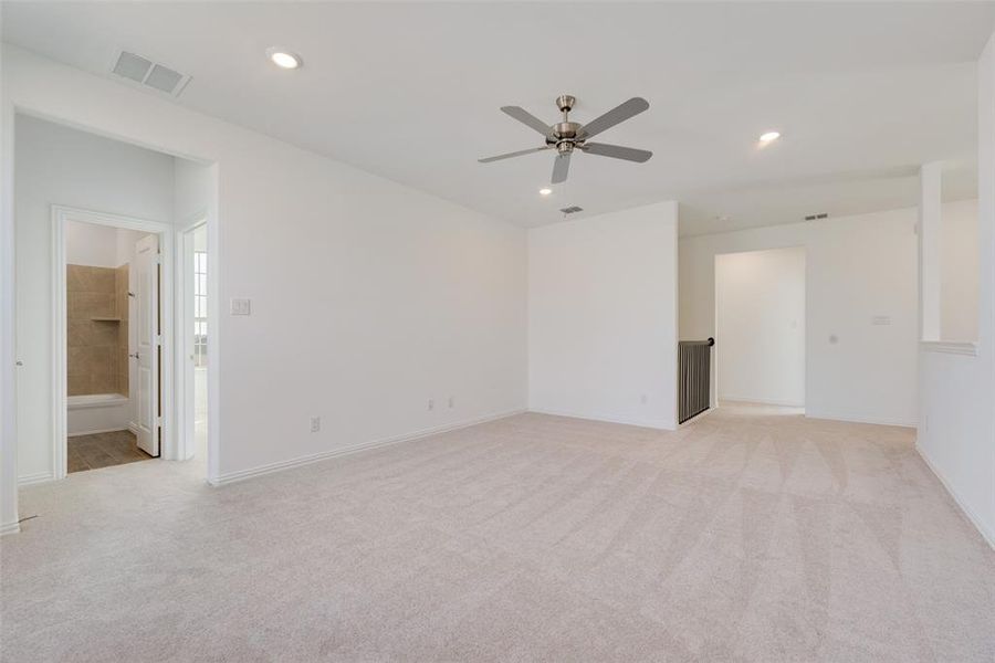 Carpeted spare room featuring ceiling fan