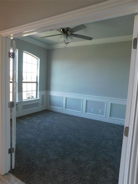 Carpeted empty room with ornamental molding and ceiling fan