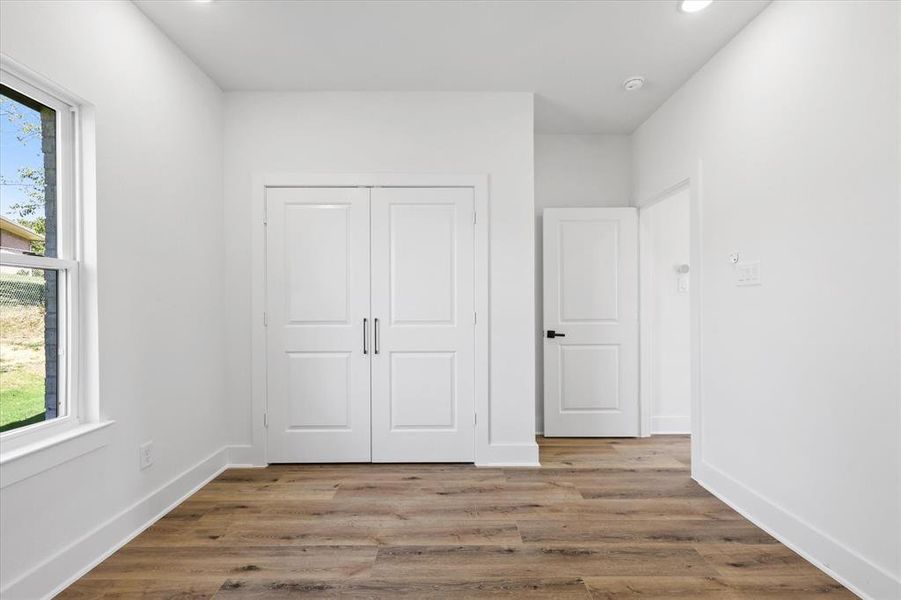 Unfurnished bedroom with light hardwood / wood-style floors and a closet