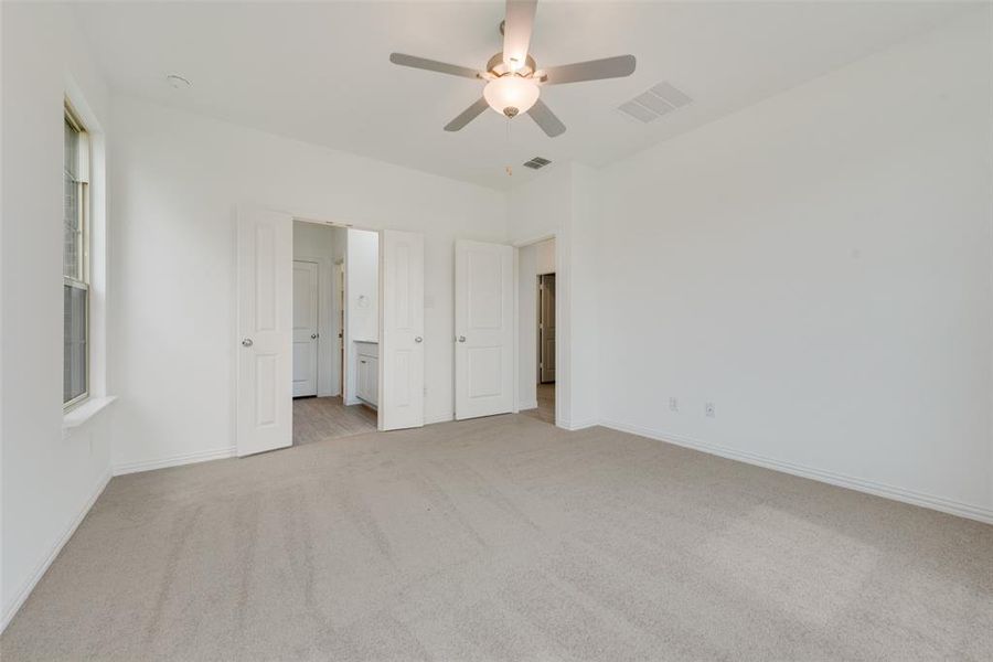 Unfurnished bedroom featuring ceiling fan and light colored carpet