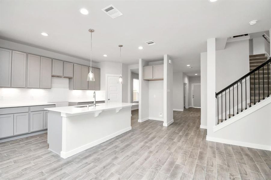 Discover another perspective of this stunning kitchen, generously appointed with an abundance of counter space. Sample photo of completed home with similar floor plan. As-built interior colors and selections may vary.