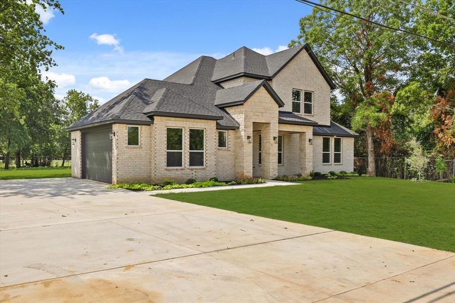 View of front of property featuring a front yard and a garage