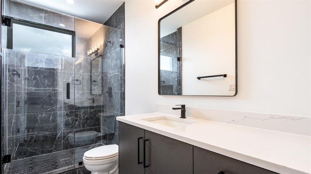 Bathroom with walk in shower, a wealth of natural light, and toilet