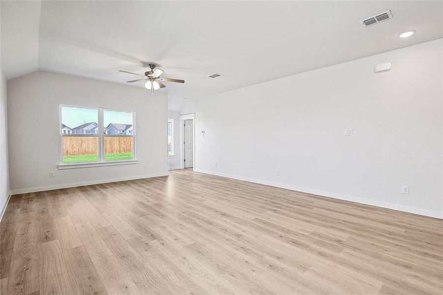 Unfurnished room featuring light wood-type flooring, vaulted ceiling, and ceiling fan