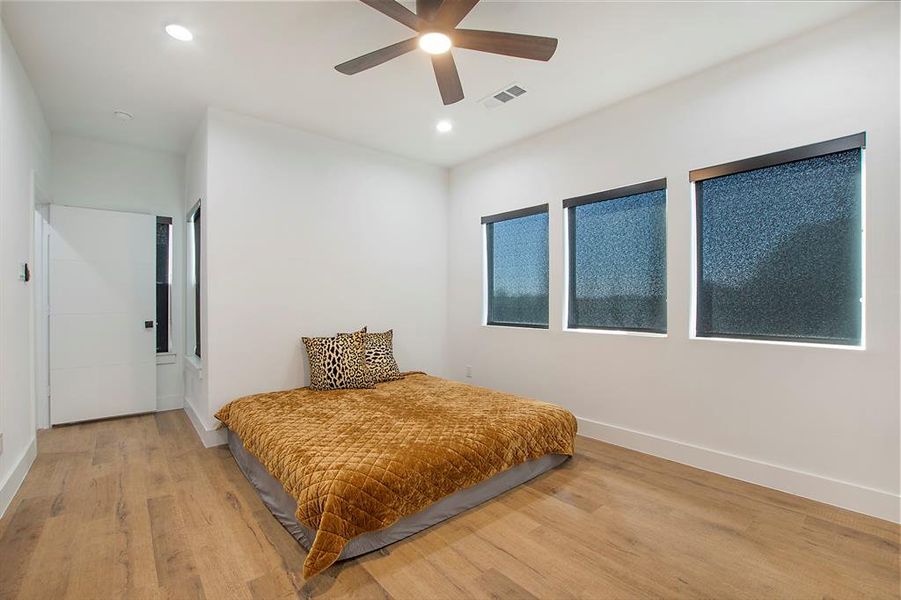 Bedroom with ceiling fan and hardwood / wood-style flooring