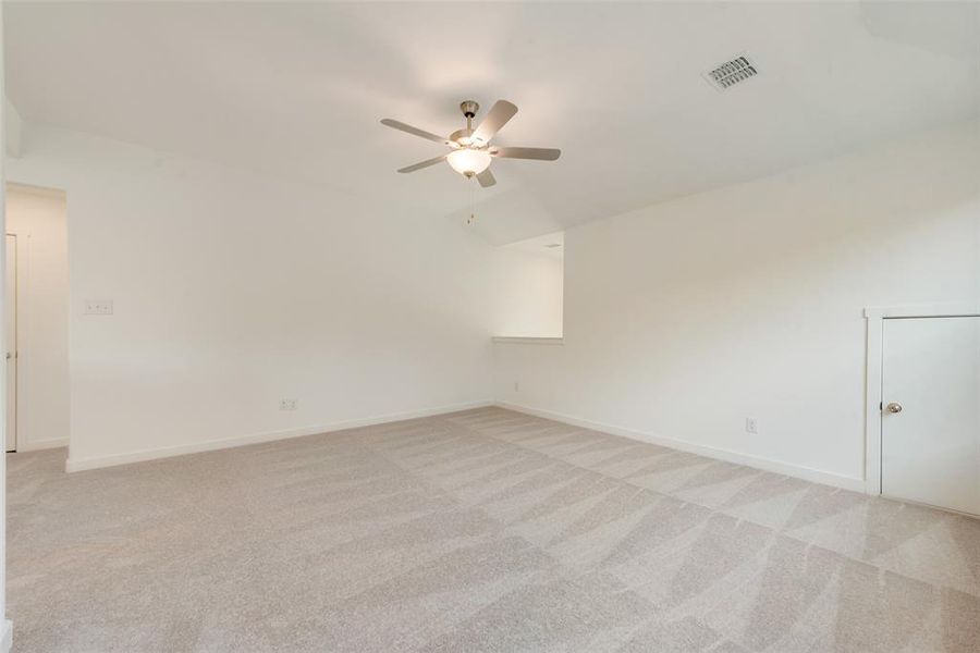 Carpeted empty room with ceiling fan