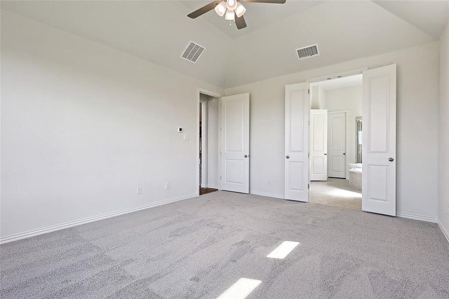 Unfurnished bedroom with light carpet, lofted ceiling, and ceiling fan