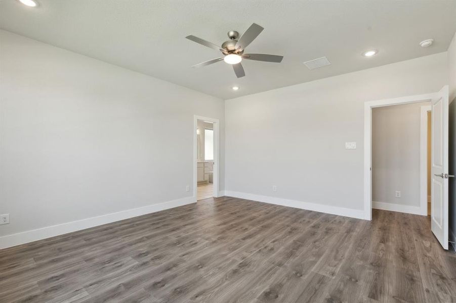 Empty room featuring dark wood-type flooring and ceiling fan