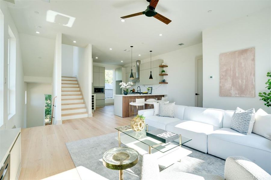 Living room with light hardwood / wood-style floors, sink, and ceiling fan