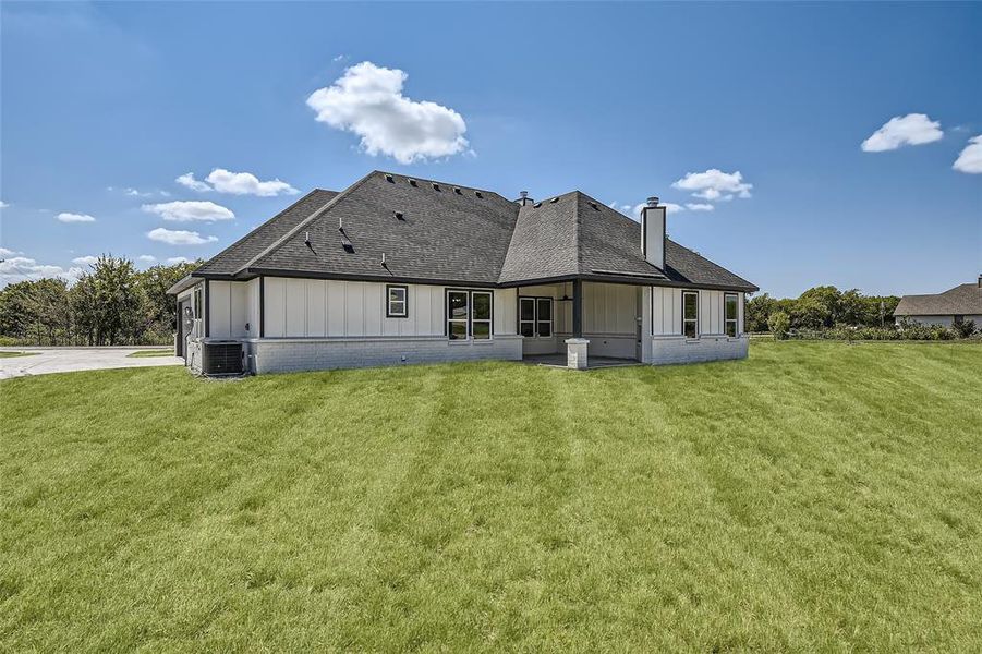 Rear view of property featuring cooling unit and a yard