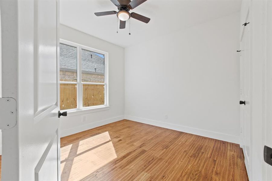 Empty room with ceiling fan and light hardwood / wood-style floors