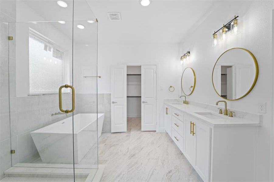 Bathroom with a shower with door, tile flooring, double sink vanity, and tile walls