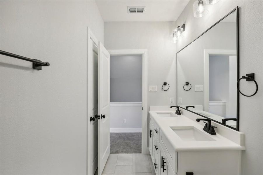 Bathroom with tile patterned floors and double vanity