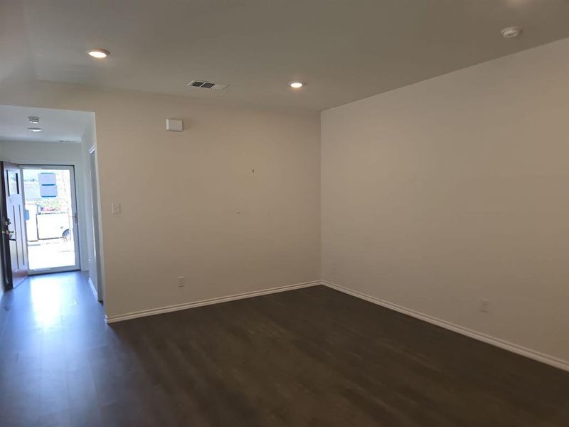 Unfurnished room with vaulted ceiling and dark wood-type flooring