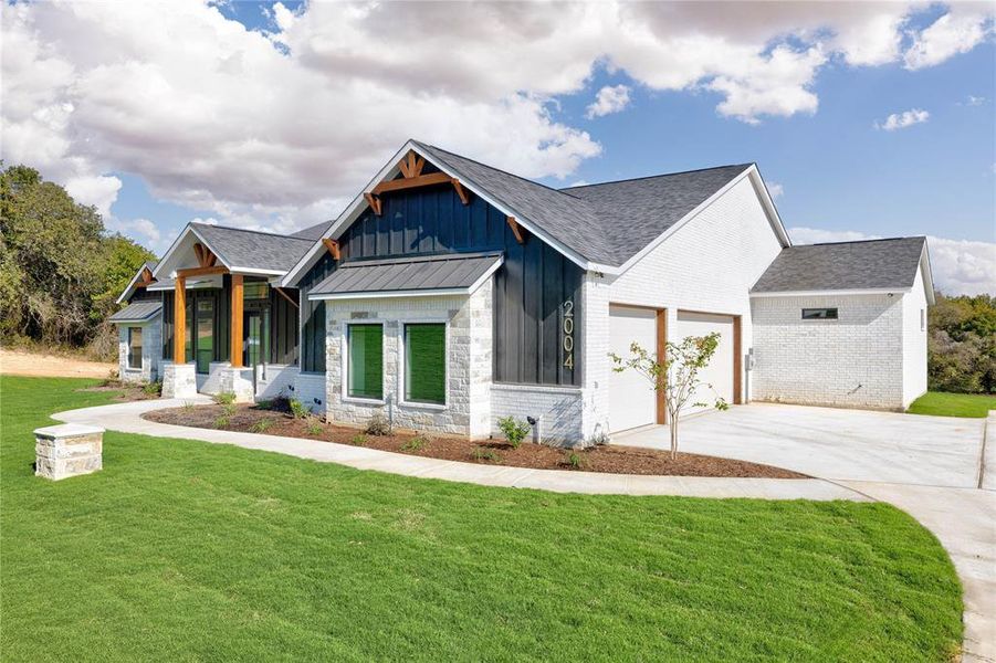 Modern farmhouse style home with a front yard and a garage